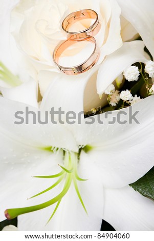 stock photo Wedding gold rings lie on a bunch of flowers for the bride