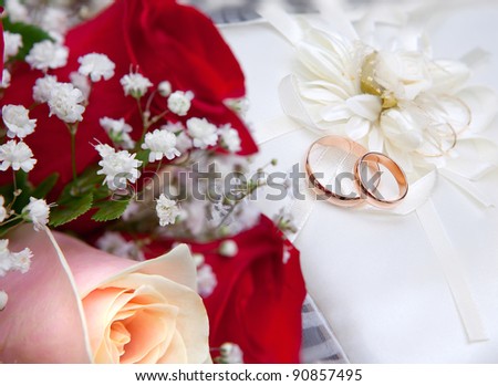 stock photo Wedding gold rings on a white pillow and bunch of flowers for