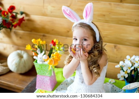 Happy easter bunny girl with easter eggs sitting in country house and celebrating easter