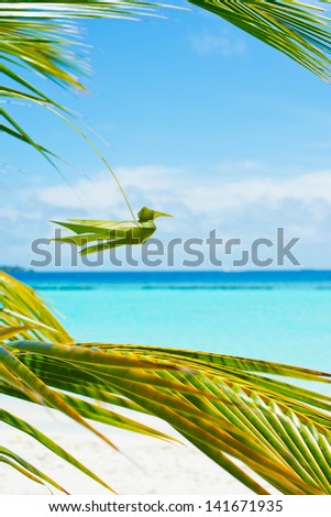 Handmade from palm leaf bird on turquoise sky