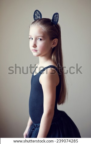 Portrait of young beautiful lonely model girl with long blond hair sad face and fancy toy ears on head in black costume