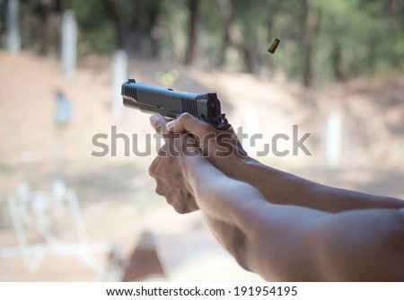 Man firing pistol at firing range