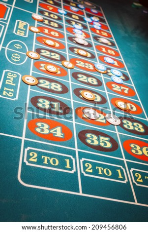 Roulette table with green felt and chips on the table