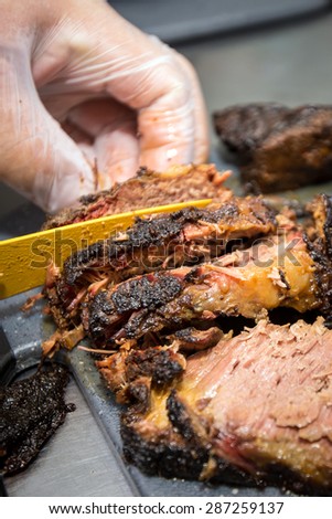 Barbecue pitmaster cuts through a delicious cut of beef brisket