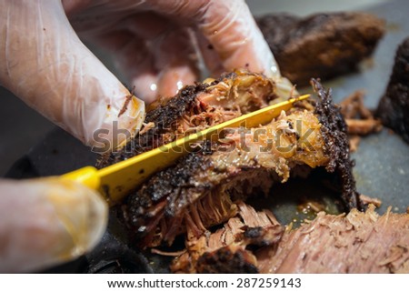 Barbecue pitmaster cuts through a delicious cut of beef brisket