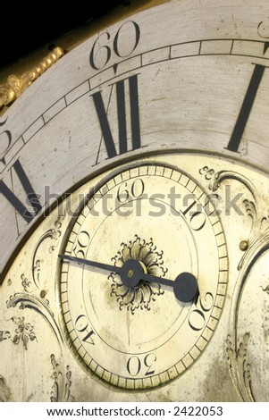 Close up of the face of an antique grandfather clock.