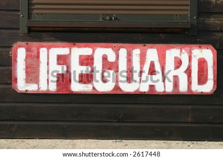 Old weathered lifeguard sign on a beach in Cornwall, UK.