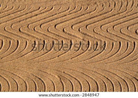 Tyre tracks in sand, making an interesting abstract pattern background.