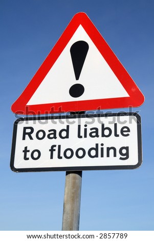 Road liable to flooding warning sign and a blue sky.