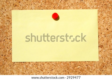 A yellow note held on a cork notice board with a red push-pin.