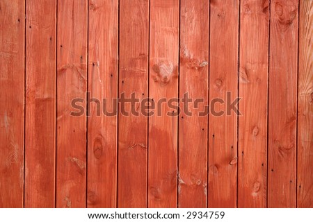 Orange / red stained wooden fence close up.