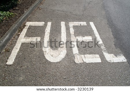 White fuel sign on a tarmac road.