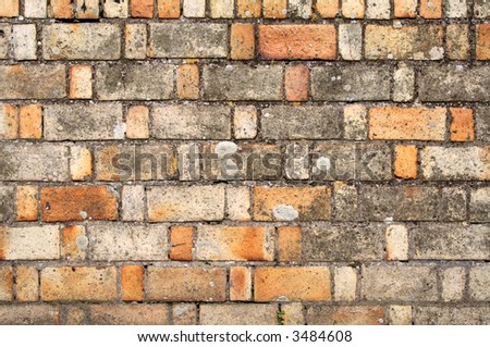 Old brick wall with varied sized and colored bricks.