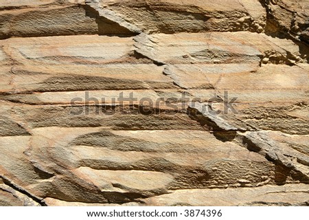 Layered rock worn away by the sea.  Natural brown colors background.