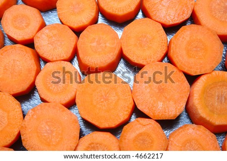Chopped carrot slices on a glass kitchen plate.