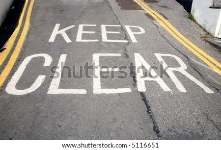 Keep clear written in white paint on a road surface.