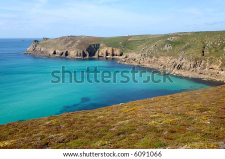 A turquoise see and colourful heather on the Cornish coast path to Lands End.