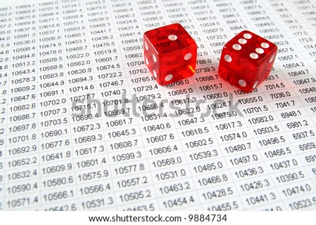 Two red dice on a spreadsheet financial data print out.