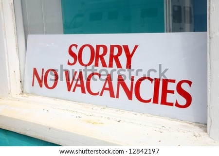 Sorry no vacancies sign in a guesthouse window.