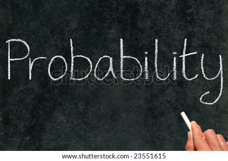 A math teacher writing probability on a blackboard.