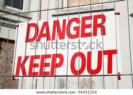 Danger keep out sign on a wire security fence.