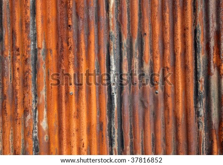 Rusty old corrugated iron fence close up.