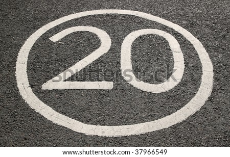 20 miles per hour sign on a tarmac road.