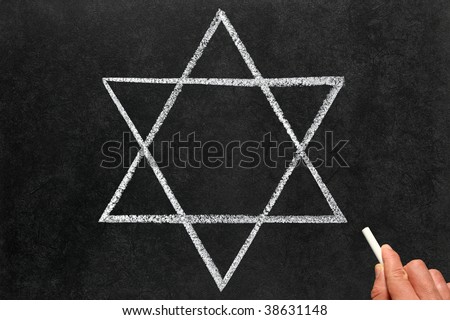 Drawing the Star of David Judaism religious symbol on a blackboard.