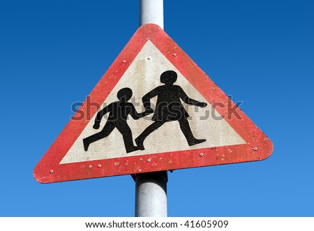 Dirty old children crossing road warning sign.