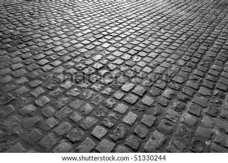 Old English cobblestone road close up in black and white.