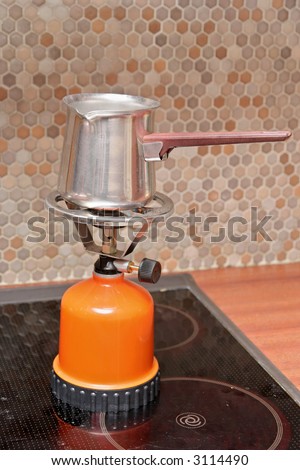 A small portable gas stove with a coffee-pot on top