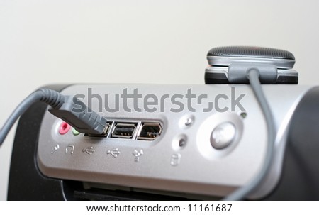 The connection of a mobile phone to the USB port of a computer (focus is on the USB port of connection and the close end of the phone)