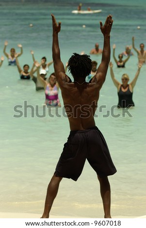 Aqua Gym: aerobics / fitness instructor in front of a group of people in the water performing exercises.