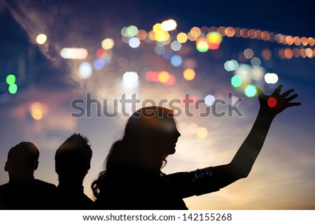 Evening walk, silhouette of three people with night lights