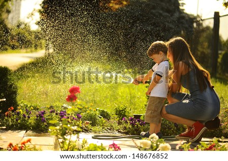 mother and son watering the lawn.