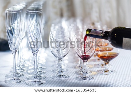 Red wine poured into wine glasses.