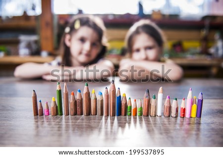 children and pencils lined up in a row
