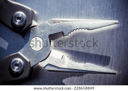 steel pliers on a steel background.