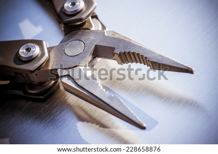 steel pliers on a steel background.