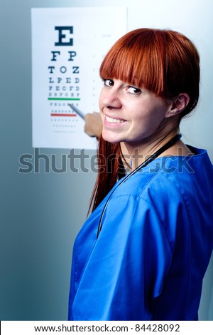 female oculist doctor examining patient with an eye chart behind