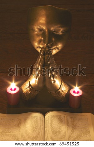 Praying hands over a spiritual book