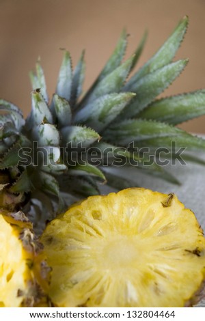 sliced pineapple with leaves on head of pineapple