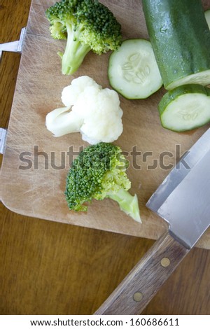 fresh vegetables with knife on cutting board