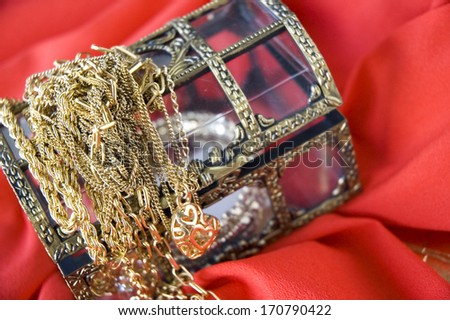 golden jewelry on treasure chest with red background