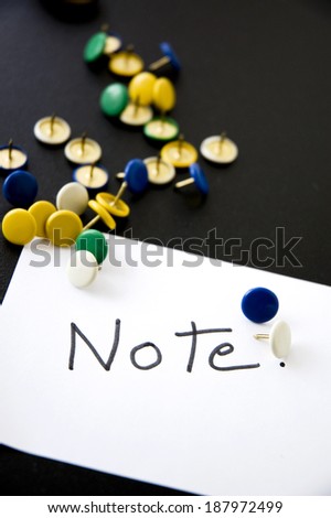 note on paper with colorful pins