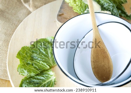 wooden spoon in bowl with fresh veggie on wooden
