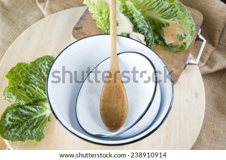 kitchenware bowl and wooden spoon with green veggie