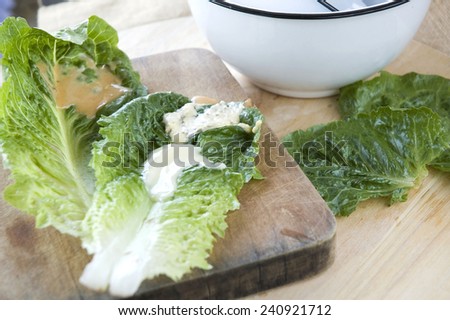 close up salad dressing on veggie with white bowl on background