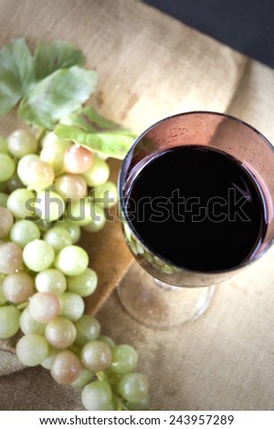 top view of red grape juice glass with grape background