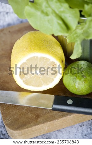 close up fresh lemon cut half with knife on cutting board